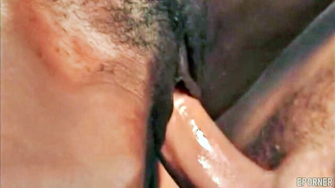 Close-up of thick black cock glistening with cum dripping from the tip