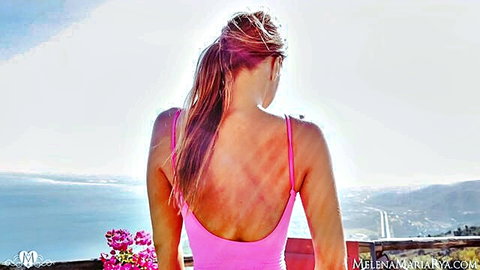 Melena Maria Rya in pink swimsuit on balcony overlooking sea