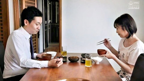 Japanese couple sharing intimate dinner with chopsticks at wooden table