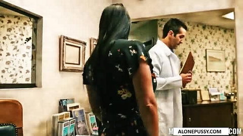 Brunette in floral dress stands before male doctor in lab coat