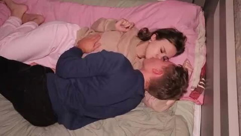 Amateur couple cuddling and kissing intimately on bed