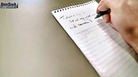 Hand writing 'Take my ass and cum' on notebook in explicit porn tease