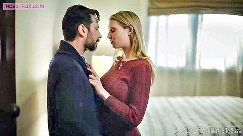 Sexy blonde babe in red sweater passionately kissing bearded stud in hotel bedroom