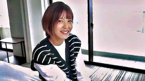 Smiling Asian woman with short brown hair in striped cardigan, solo softcore