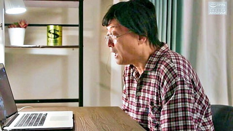 Shocked older Japanese man in glasses and plaid shirt gaping wide-eyed at laptop screen