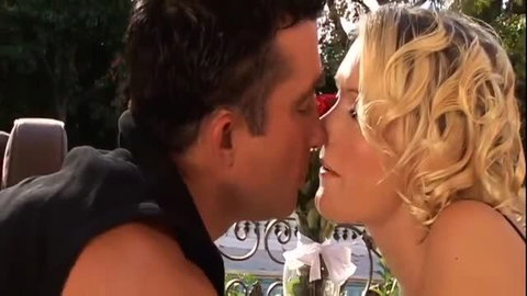 Blonde woman and man in close romantic kiss outdoors