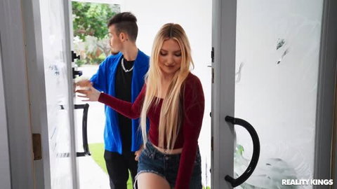 Britt Blair in red velvet top and denim skirt at doorway