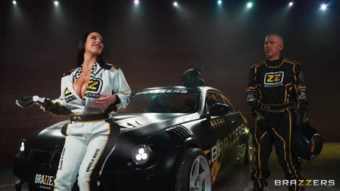 Angela White in Brazzers racing suit with big tits beside Mick Blue and Formula Cum car