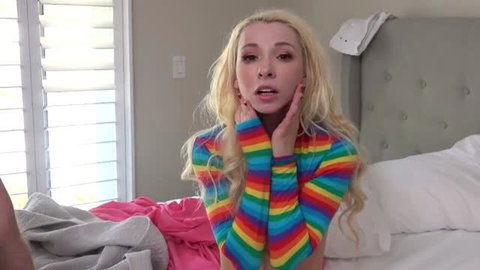 Kenzie Reeves in rainbow crop top, shocked expression on bed