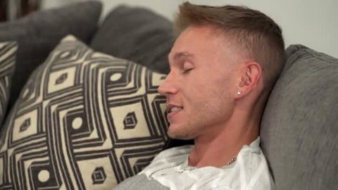 Blonde male model resting on couch in casual shirt