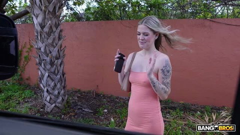 Aubree Blair in pink dress holding black bottle by Bang Bus