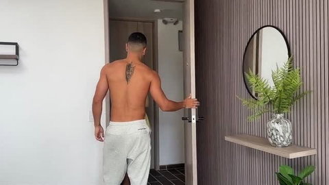 Max Betancur shirtless from behind with back tattoo entering room