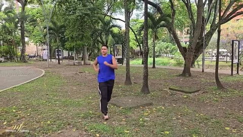 Man in blue tank top jogging in park