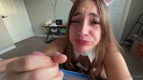 Sarah Rhyder in schoolgirl outfit with pink cat ears, tearful expression
