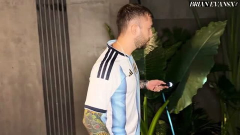 Brian Evansx in Argentina jersey with tattooed arm holding mic