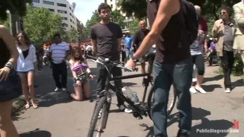 Dulce Mariposa on knees in public BDSM blowjob scene