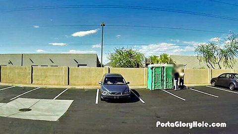 Outdoor porta gloryhole setup in parking lot with blurred figures
