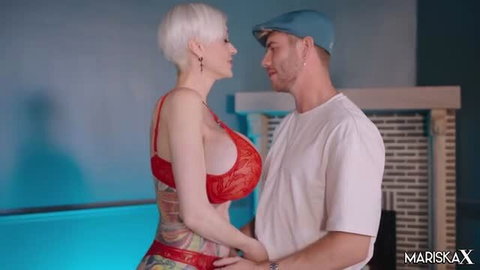 Tanya Virago in red lace lingerie with short white hair facing muscular man