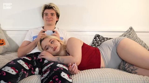 Nika Legran blonde in red top and grey shorts cuddling on bed