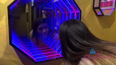 Aubry Babcock in neon-lit mirror selfie, long dark hair, softcore tease