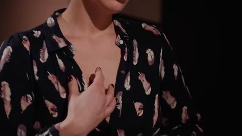 Woman in unbuttoned feather print shirt revealing cleavage