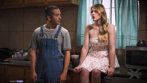 Melody Marks in Honey Do, sitting in kitchen wearing floral dress, man in overalls