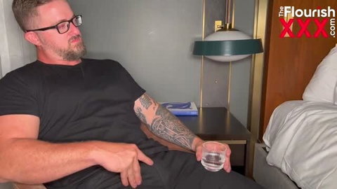Brick Kummings in black t-shirt holding drink in hotel room