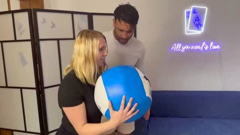 Lola in black top with large blue and white ball, softcore scene