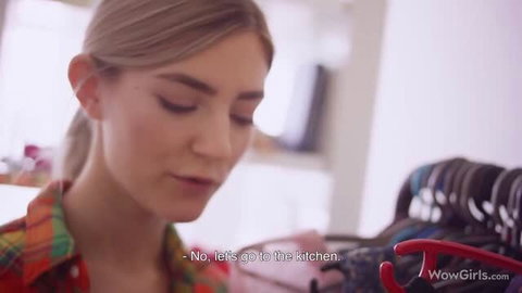 Eva Elfie with blonde ponytail in plaid shirt looking down
