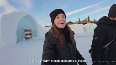 Hermione Potter smiling in winter coat outside ice hotel